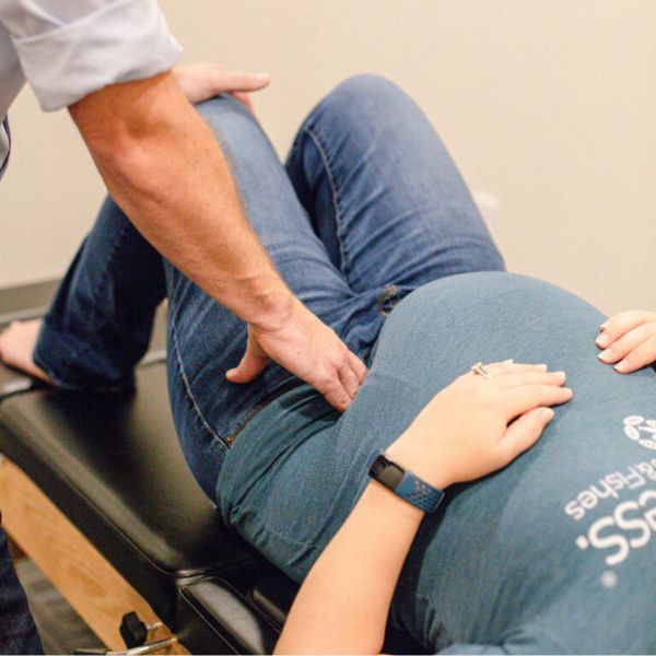chiropractor giving adjustments to pregnant woman at the wellery