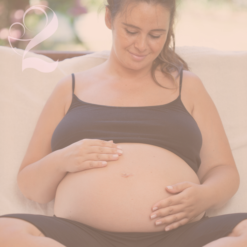 Pregnant woman smiling down at her belly