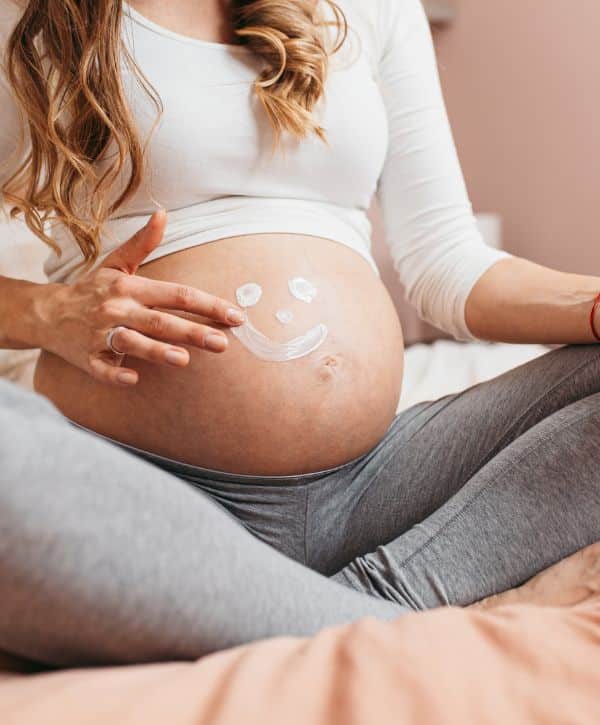 Woman sitting with a pregnant belly learning about what to expect when youre expecting