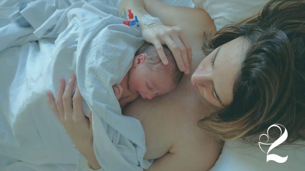 New mom holding baby on her chest after a successful childbirth and taking the childbirth ed class from How2Mom